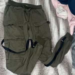 Male Olive green cargo pants with multiple pockets and black strings.